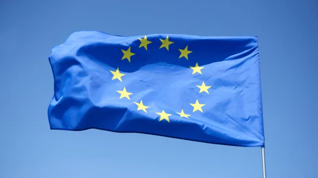 Flaga Unii Europejskiej na tle błękitnego nieba