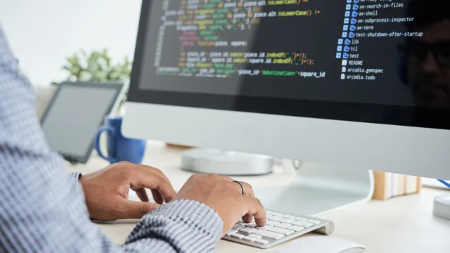 Programista piszący kod przy komputerze