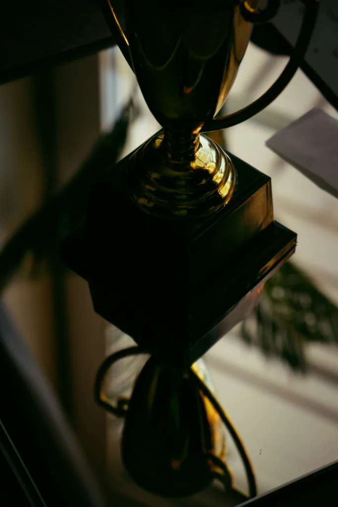 Złote trofeum na czarnej podstawie